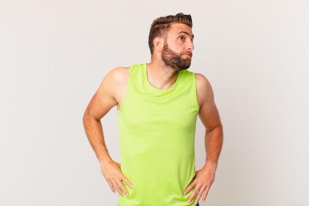 Photo young handsome man shrugging, feeling confused and uncertain