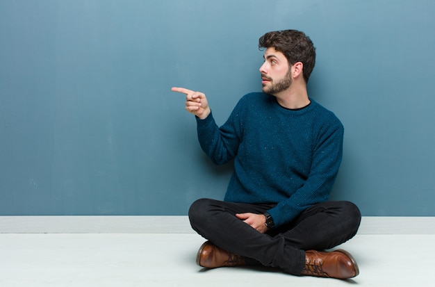 Young handsome man sitting on floor