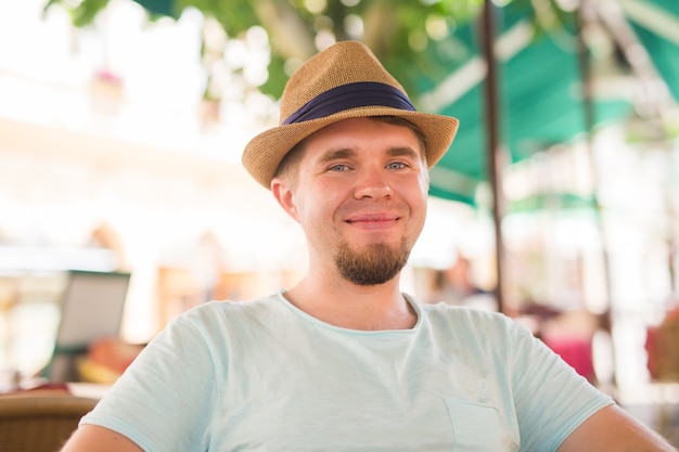 Young handsome man sitting in a street cafe.