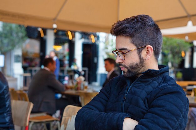 Young handsome man sitting at a terrace