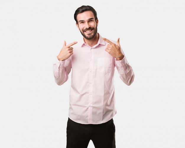 Young handsome man smiles, pointing mouth