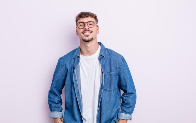 Young handsome man smiling cheerfully and casually with a positive, happy, confident and relaxed expression