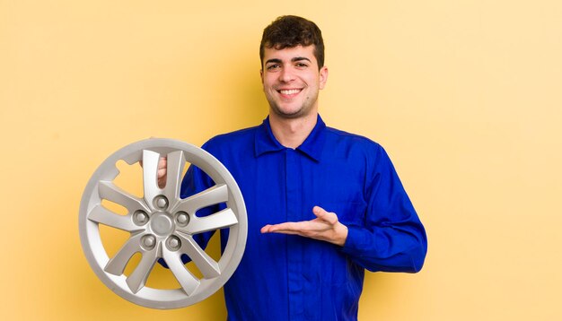 Young handsome man smiling cheerfully feeling happy and showing a concept car repairman concept