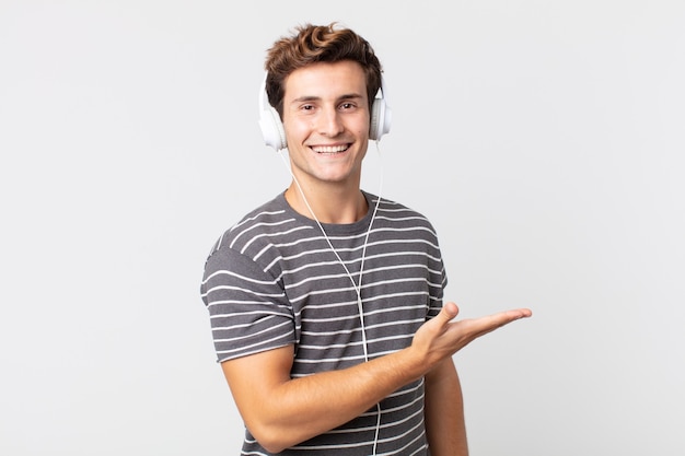 Young handsome man smiling cheerfully, feeling happy and showing a concept. listening music concept