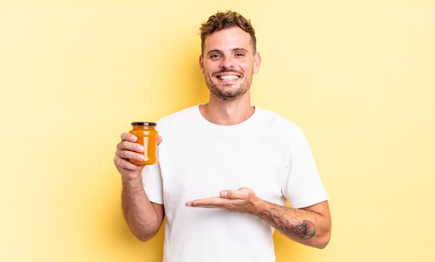 Young handsome man smiling cheerfully, feeling happy and showing a concept. peach jelly concept