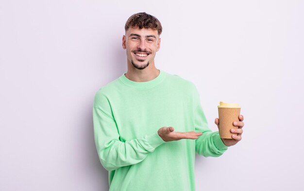 Young handsome man smiling cheerfully, feeling happy and showing a concept. take away coffee concept