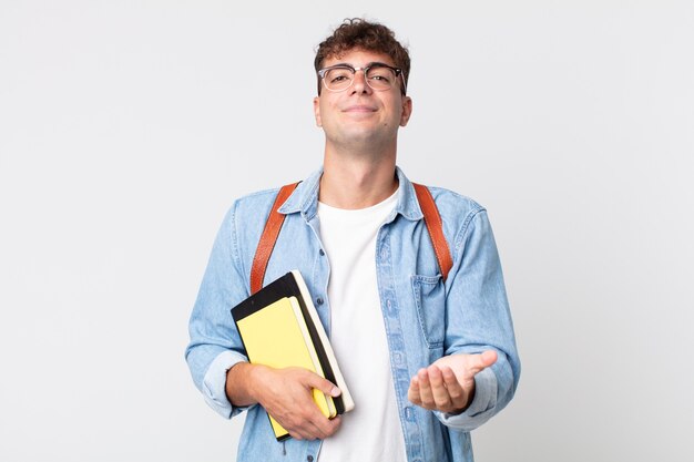 Foto giovane uomo bello che sorride felicemente con amichevole e offrendo e mostrando un concetto. concetto di studente universitario