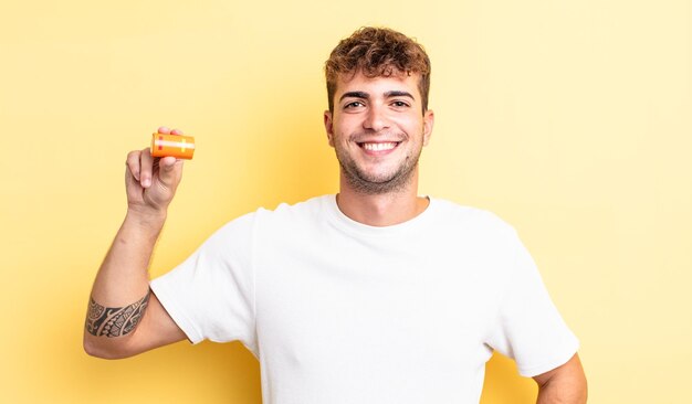 Young handsome man smiling happily with a hand on hip and confident with a battery