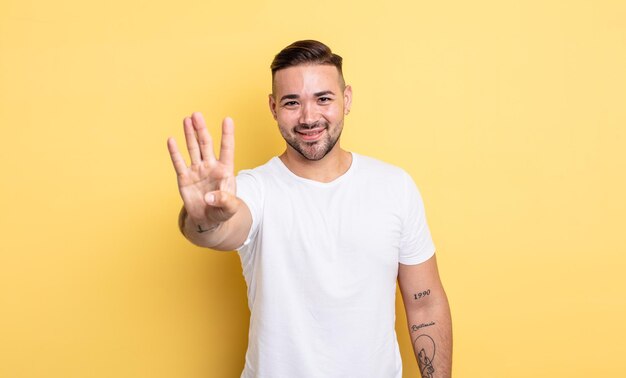 Young handsome man smiling and looking friendly, showing number four or fourth with hand forward, counting down