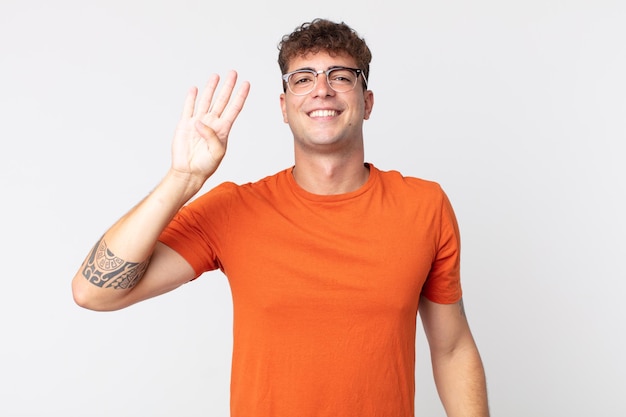 Young handsome man smiling and looking friendly, showing number four or fourth with hand forward, counting down