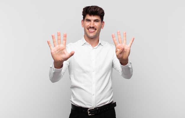 Giovane uomo bello sorridente e guardando amichevole, mostrando il numero nove o nono con la mano in avanti, conto alla rovescia