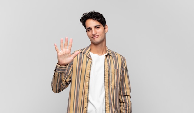 Young handsome man smiling and looking friendly