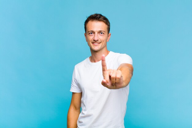 Young handsome man smiling proudly and confidently