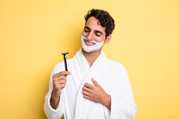 Young handsome man smiling with a happy, confident expression with hand on chin. shaving and foam concept