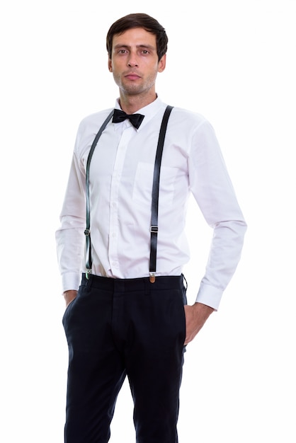 young handsome man standing while wearing suspenders and bow tie