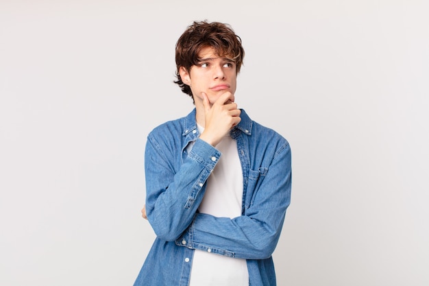 young handsome man thinking, feeling doubtful and confused