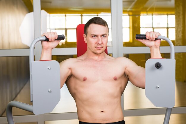 Young handsome man training in gym