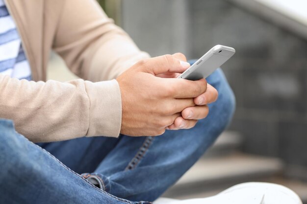 Young handsome man using his mobile phone outdoors