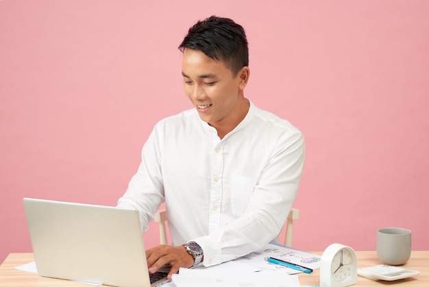 Young handsome man using laptop in his officeAsian