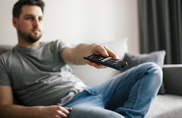 Young handsome man watching TV