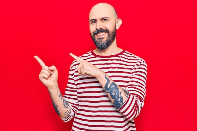 Young handsome man wearing casual clothes smiling and looking at the camera pointing with two hands and fingers to the side