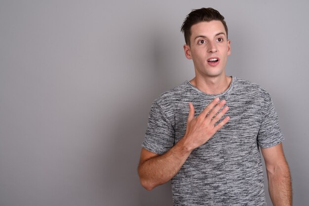 young handsome man wearing gray shirt on gray