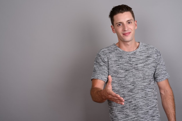 young handsome man wearing gray shirt on gray