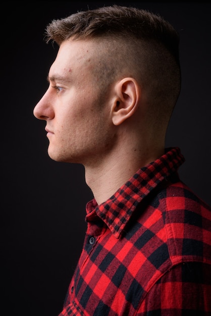 Photo young handsome man wearing red checkered shirt on gray