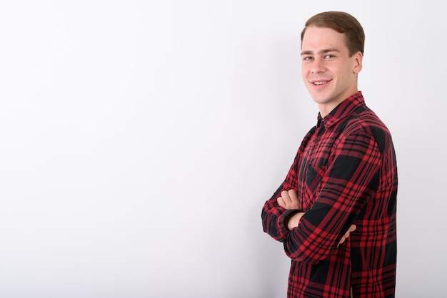 Young handsome man wearing red checkered shirt on white wall