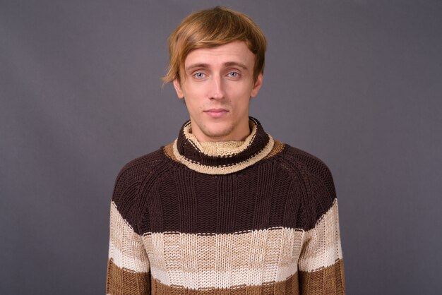 タートルネックのセーターを着ている若いハンサムな男