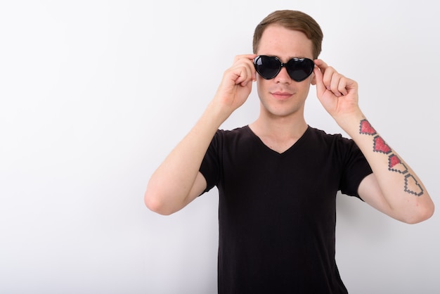 Young handsome man on white wall