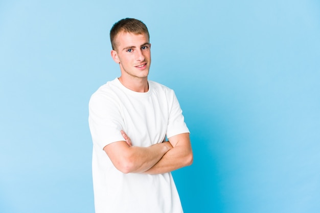 Photo young handsome man who feels confident, crossing arms with determination