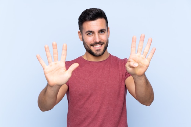 Giovane uomo bello con la barba isolata contando nove con le dita