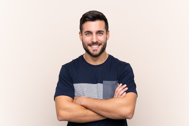 Young handsome man with beard over isolated keeping the arms crossed in frontal position