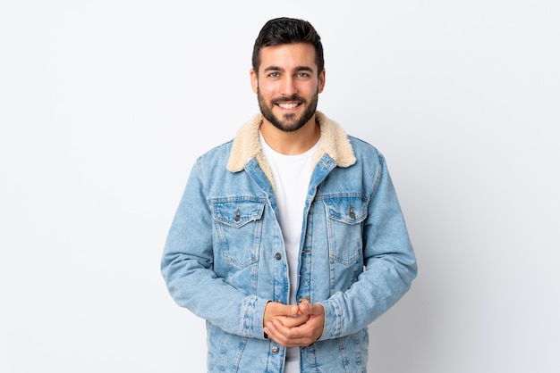 Young handsome man with beard isolated on white wall laughing