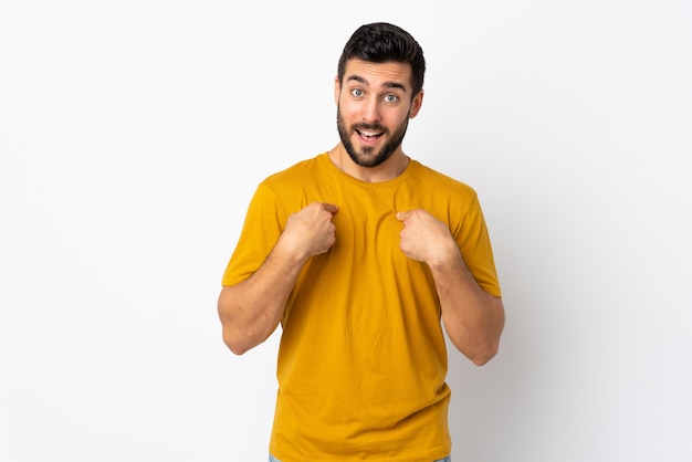 Young handsome man with beard on white wall with surprise facial expression