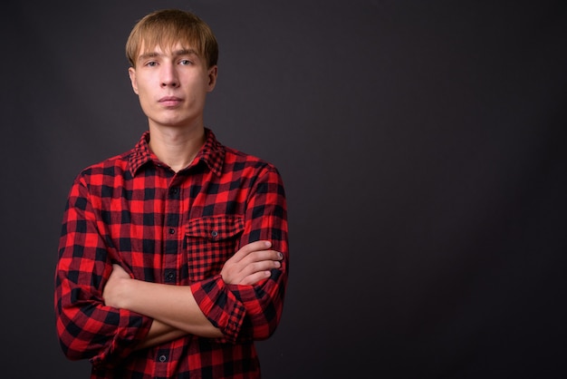 Young handsome man with blond hair on gray