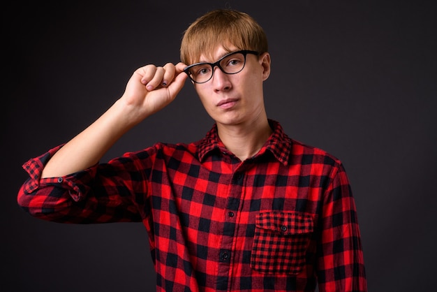 Young handsome man with blond hair on gray