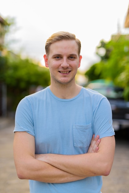 Young handsome man with blond hair in the streets outdoors