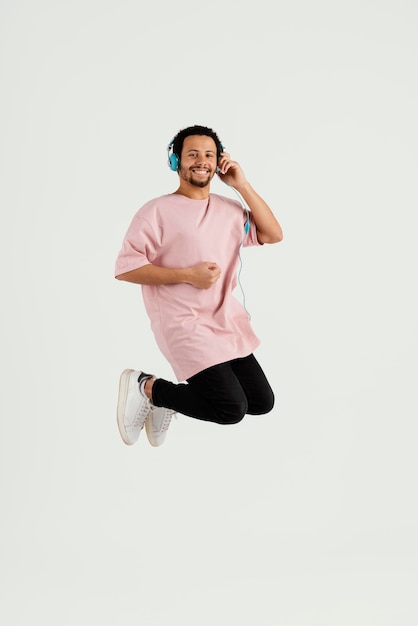 young handsome man with headphones jumping