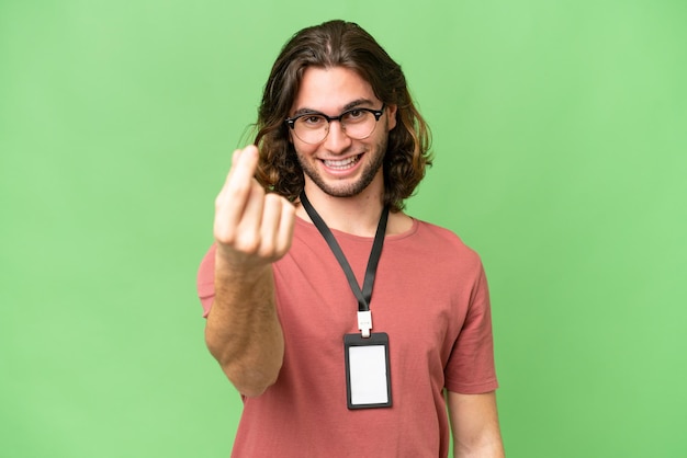 Young handsome man with ID card over isolated background making money gesture