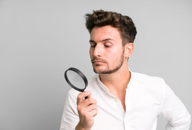 Young handsome man with a magnifying glass search or find\
concept