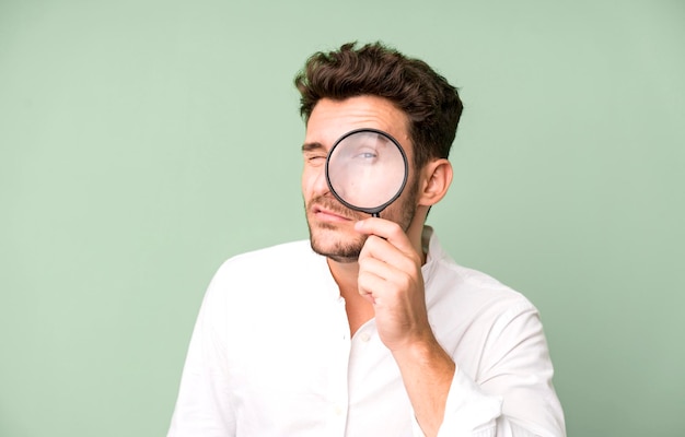 Young handsome man with a magnifying glass search or find\
concept