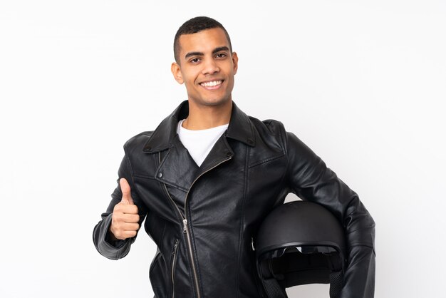 Young handsome man with a motorcycle helmet over isolated white wall giving a thumbs up gesture