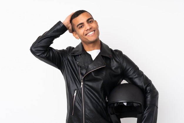 Young handsome man with a motorcycle helmet over isolated white wall laughing