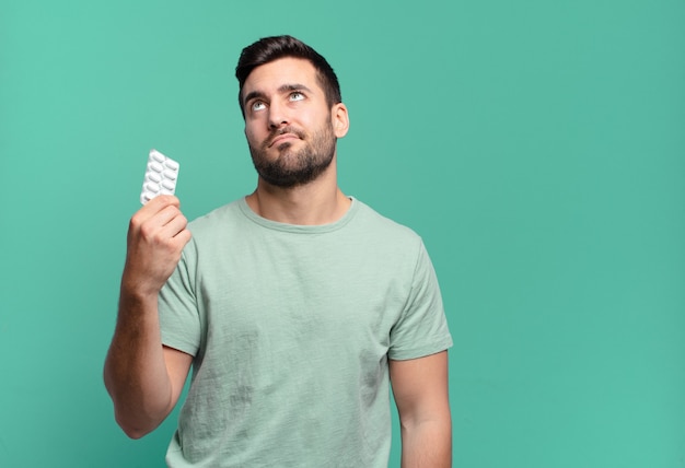 Young handsome man with a pills tablet. illness or ache concept