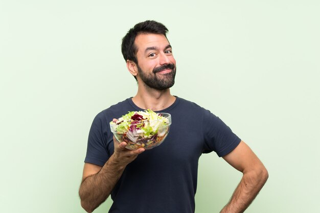 Young handsome man with salad smiling