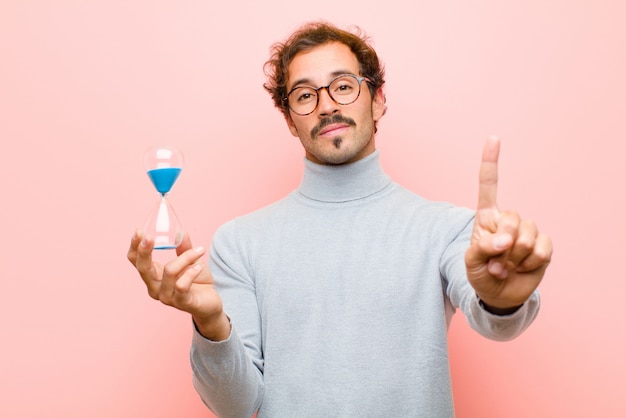 Young handsome man with a sand clock timer