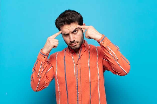 Young handsome man with a serious and concentrated look, brainstorming and thinking about a challenging problem