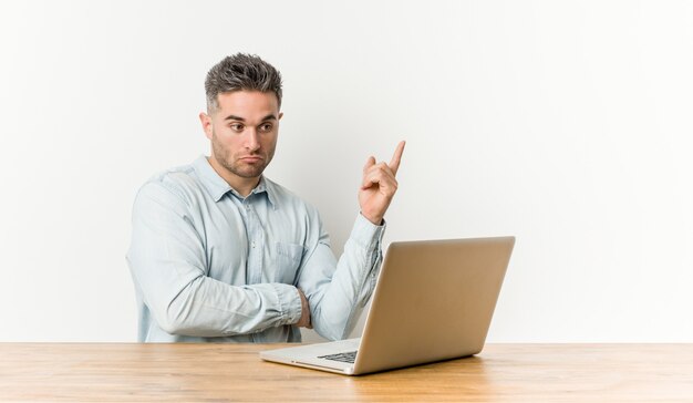 Young handsome man working with his laptop having some great idea, concept of creativity.